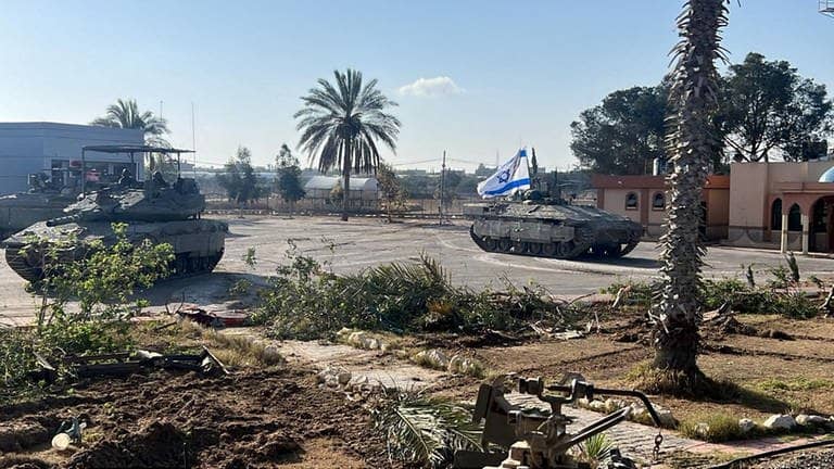 Israelische Panzer, einer davon mit einer gehissten Israel-Flagge, auf der palästinensischen Seite des Grenzübergangs bei Rafah im Gazastreifen