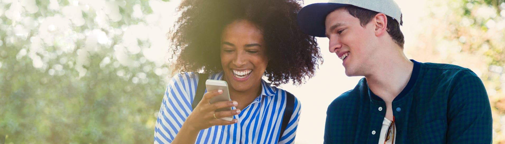 Zwei fröhliche Menschen lesen gute Nachrichten auf einem Smartphone