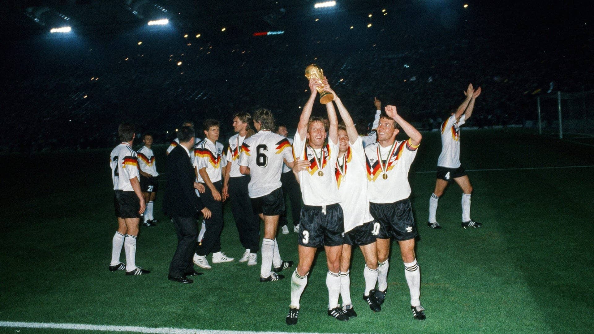 Andreas Brehme, Thomas Häßler und Lothar Matthäus am 9.7.1990 mit dem WM-Pokal in Italien nach dem Spiel Deutschland-Argentinien