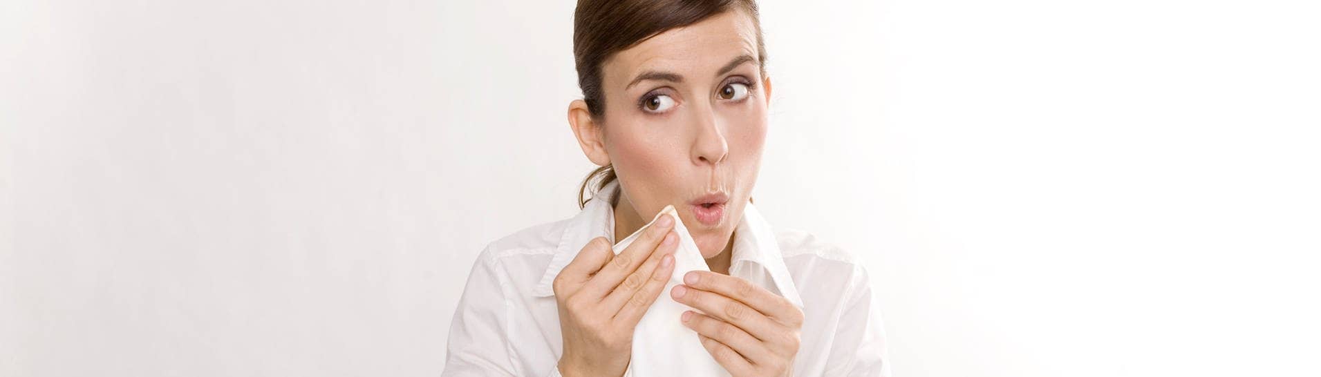 Junge Frau tupft sich beim Essen mit der Serviette den Mund ab