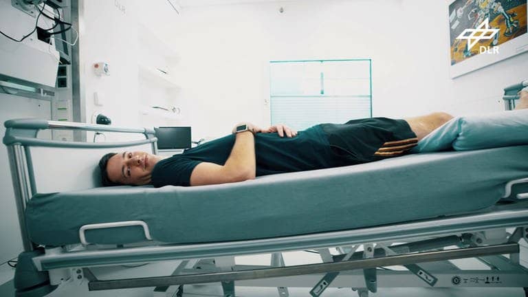 Die DLR führt eine Bettruhestudie durch. Dabei liegt ein Teilnehmer in einem sechs Grad geneigten Bett. (Foto: DLR)