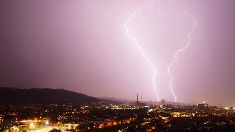 Zwei Blitze entladen sich während eines Gewitters hinter dem Gaskessel in Stuttgart. Der Deutsche Wetterdienst (DWD) hat bis Samstag vor Unwettern in weiten Teilen Baden-Württembergs gewarnt. Es könne es zu schweren Gewittern kommen, teilte der DWD mit.