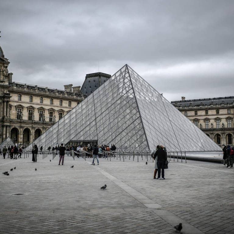 Touristen besuchen die Glaspyramide im Innenhof des Louvre. - Das Museum wurde wegen einer Bombendrohung gesperrt.