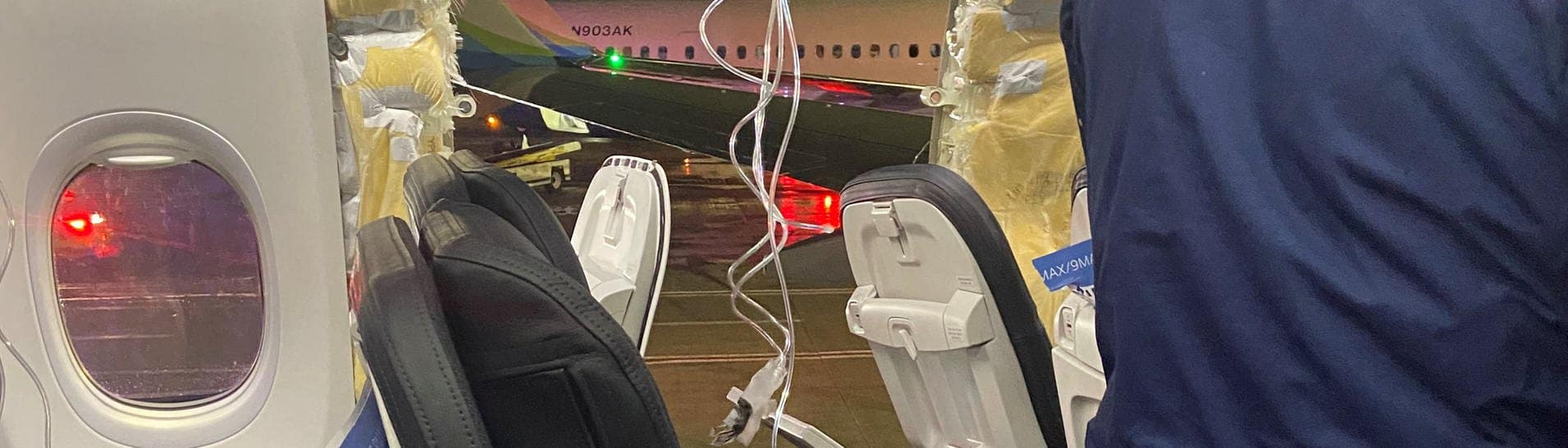 Sauerstoffmasken hängen vor dem Loch in der Wand eines Flugzeugs der Alaska Airlines