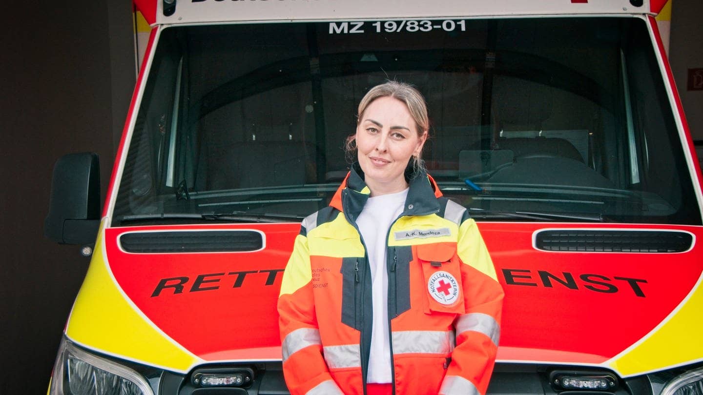 Anne Mendoza steht vor einem Krankenwagen. Sie ist Notfallsanitäterin und Leiterin der Rettungswache in Nieder-Olm, in der Nähe von Mainz. Seit sie 18 ist, fährt sie Rettungseinsätze.Sie sagt, Gewalt gegen Rettungskräfte kennt jede Einsatzkraft.