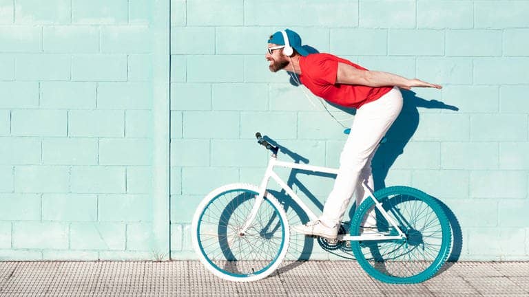 Ein Mann mit Kopfhörern auf einem Fahrrad – ob das legal ist?