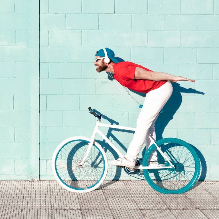 Ein Mann mit Kopfhörern auf einem Fahrrad – ob das legal ist? (Foto: IMAGO, Addictive Stock)