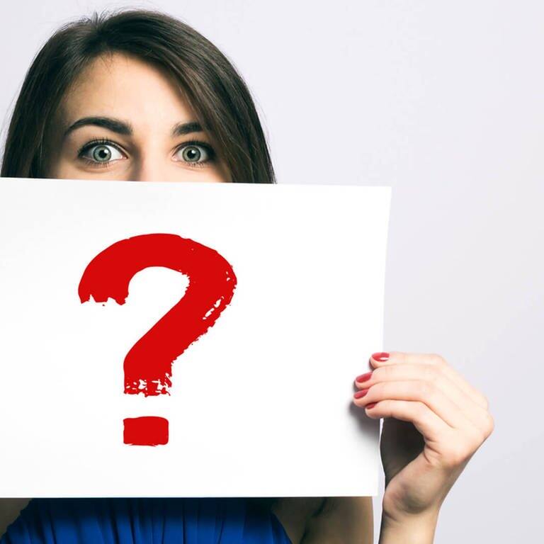 Frau hält ein Blatt mit einem Fragezeichen - FAQ