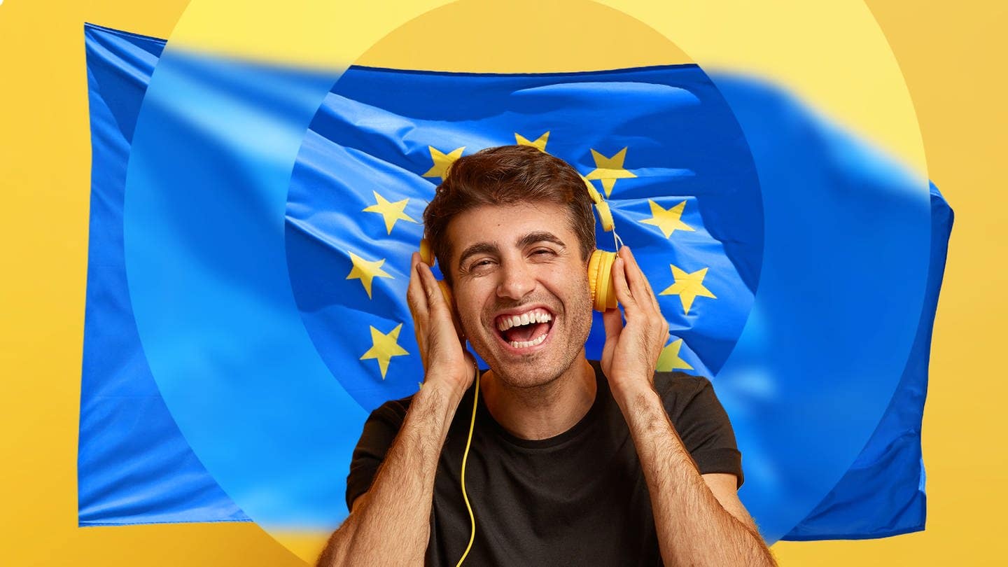 Junger Mann mit Kopfhörern vor Europa-Flagge