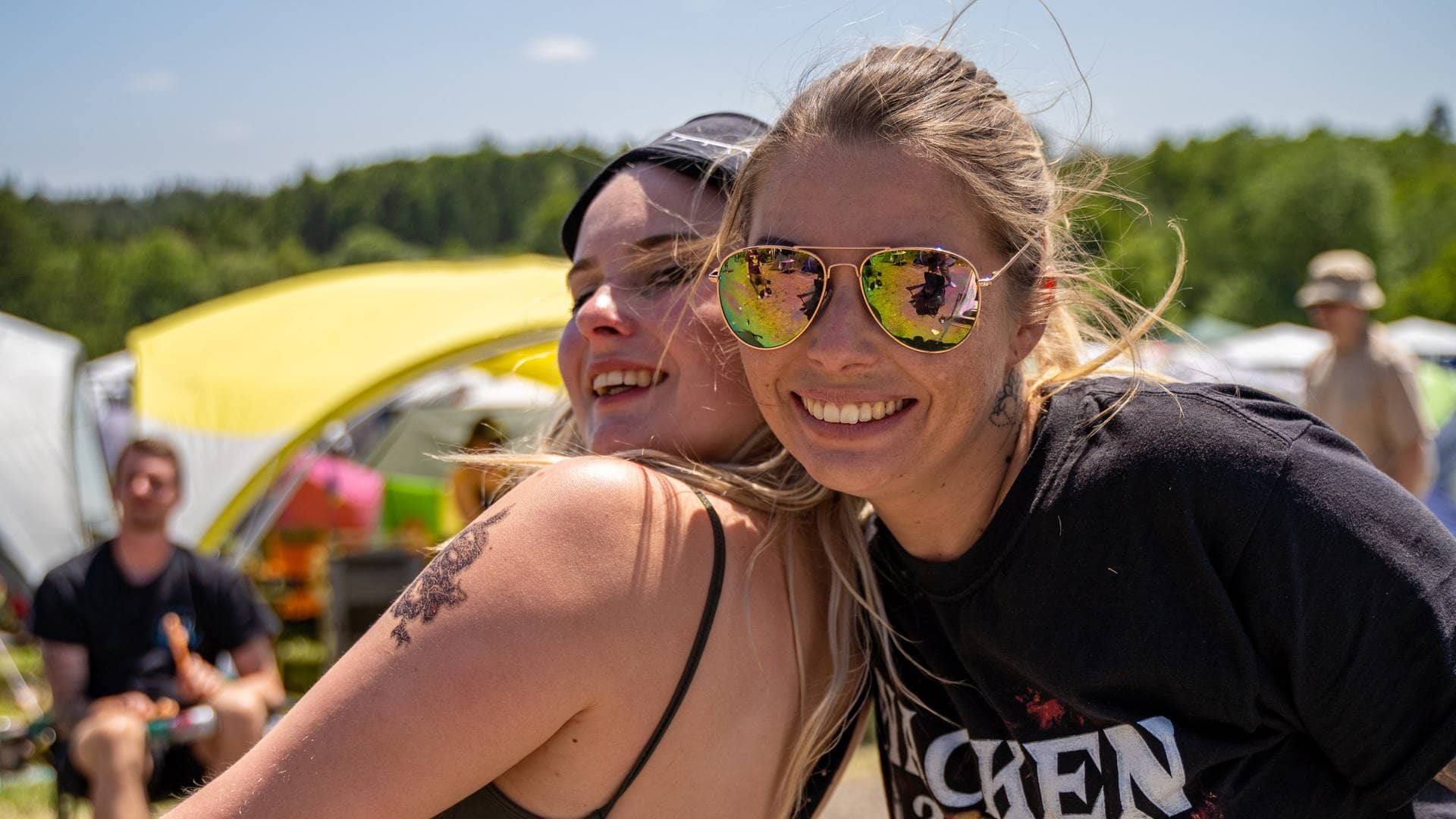 Zwei junge Frauen auf dem Campingplatz bei Rock am Ring lachen in die Kamera