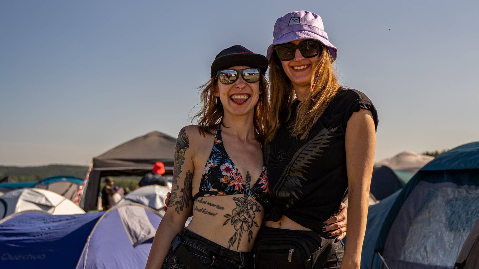 Zwei junge Frauen stehen vor Zelten auf dem Campingplatz von Rock am Ring