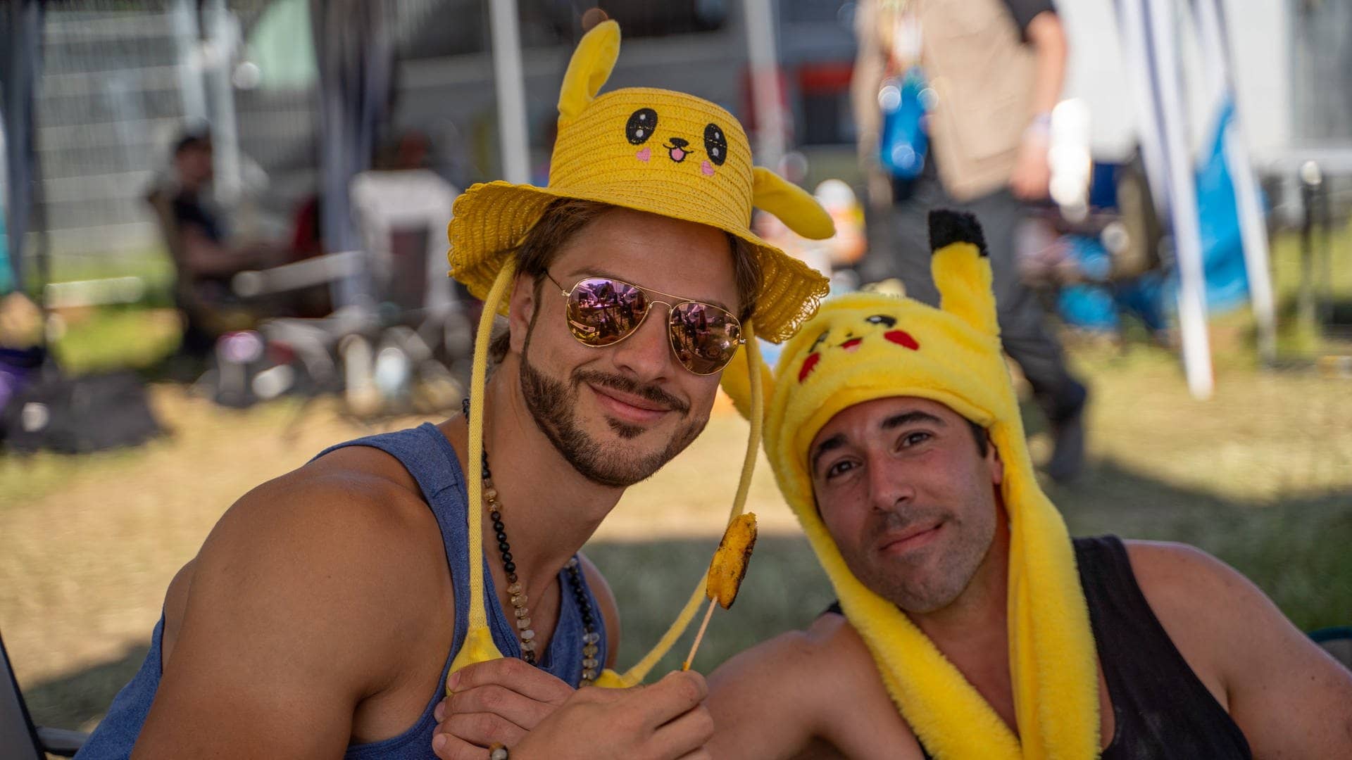 Zwei Männer mit gelben Pikachu-Hüten sind vor Zelten bei Rock am Ring