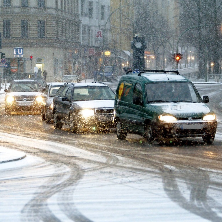 Mehrere Autos fahren bei Schnee im Stadtverkehr. (Foto: IMAGO, Contrast/Streubel)
