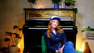 Portraitbild Palina Rojinski vor Klavier mit Folgenzahl 2