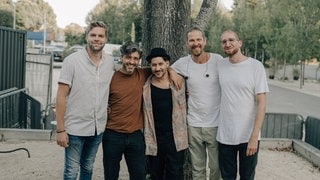 Die Band La Diri steht vor einem Baumstamm