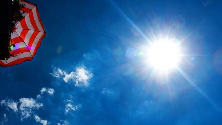 Sonne brennt, Sonnenschirm und blauer Himmel (Foto: dpa Bildfunk, dpa-Zentralbild)