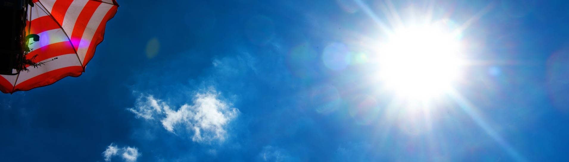 Sonne brennt, Sonnenschirm und blauer Himmel (Foto: dpa Bildfunk, dpa-Zentralbild)