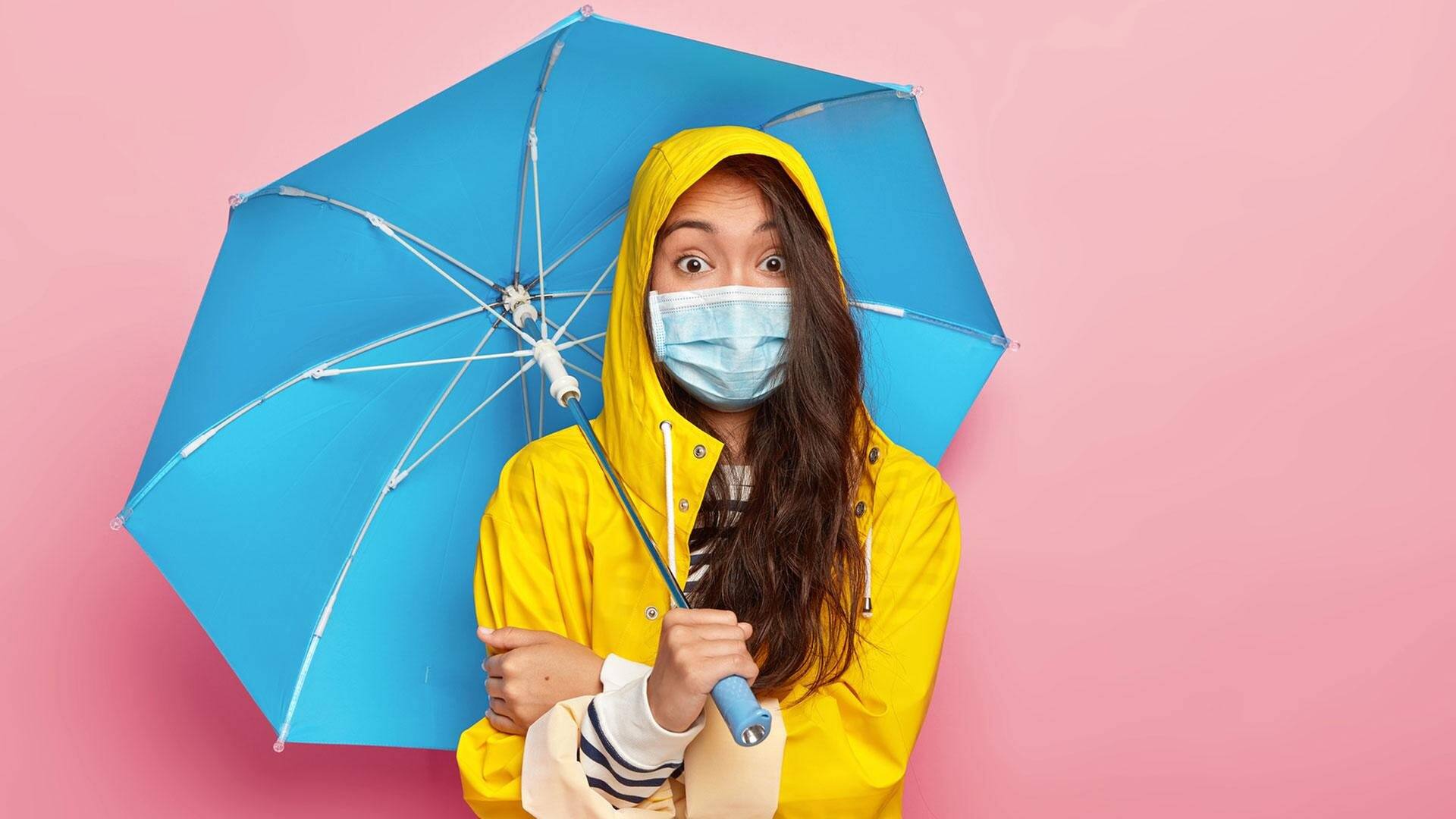 Frau mit Mundschutz, Regenschirm und erschrockenen Augen (Foto: Fotolia © Wayhome Studio)