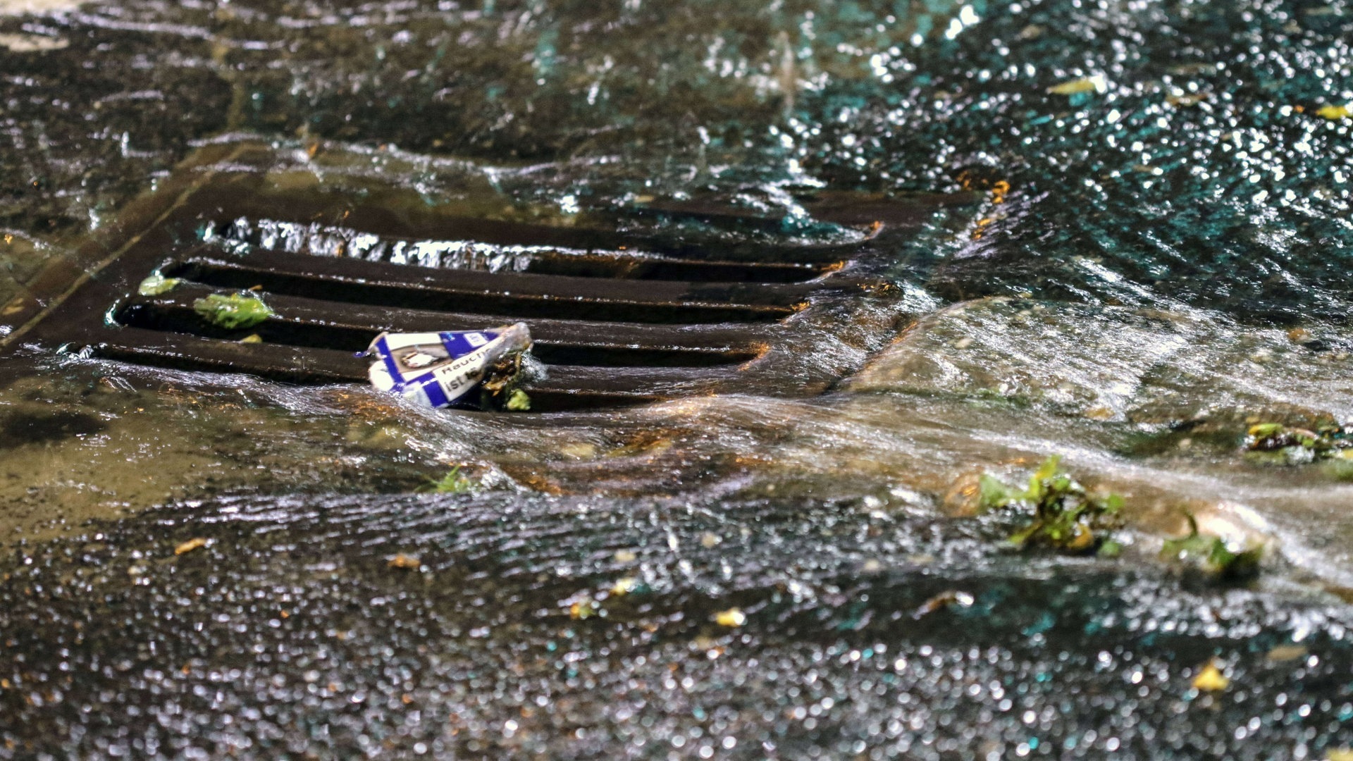 Foto: IMAGO, IMAGO / Gottfried Czepluch Gullideckel läuft mit Wasser voll (Foto: IMAGO, IMAGO / Gottfried Czepluch)