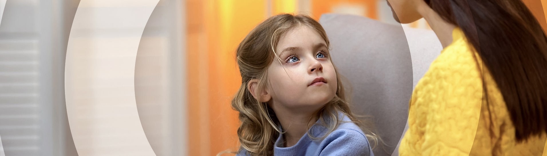 Mutter sitzt mit Tochter auf dem Sofa, Kind schaut Mutter erwartungsvoll an. (Foto: Adobe Stock/motortion)