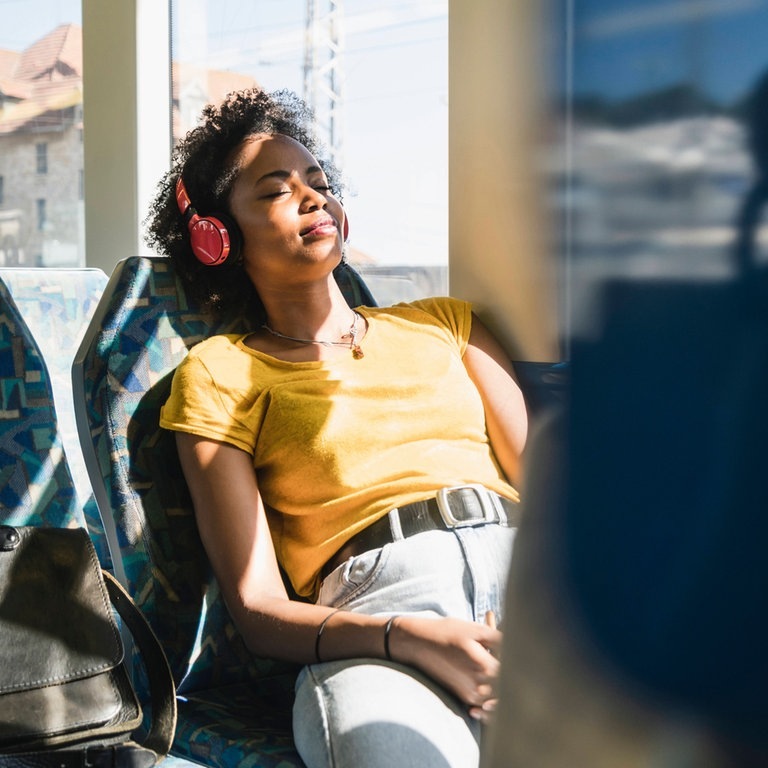 Frau fährt im Sommer mit der Bahn im Nahverkehr (Foto: IMAGO, Westend61)