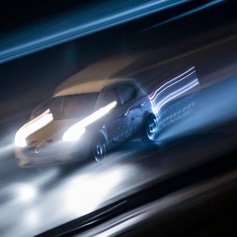 Schnell fahrendes Auto in der Nacht (Foto: dpa/picture-alliance)