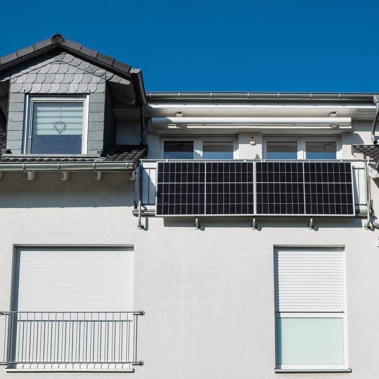 Mehrfamilienhaus mit zwei Solarpanelen am Balkongeländer (Foto: IMAGO, Robert Poorten)