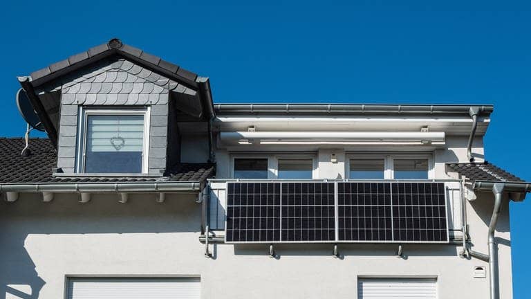 Mehrfamilienhaus mit zwei Solarpanelen am Balkongeländer (Foto: IMAGO, Robert Poorten)