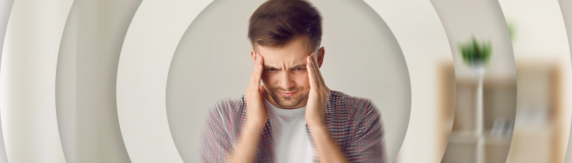 Junger Man hält sich den Kopf (Foto: Adobe Stock / Studio Romantic)