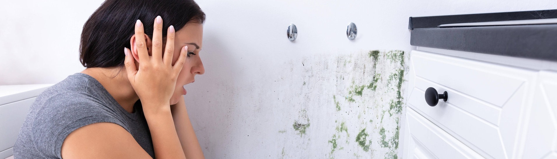 Frau erschrickt sich vor Schimmel an der Wand (Foto: IMAGO, IMAGO / Panthermedia)