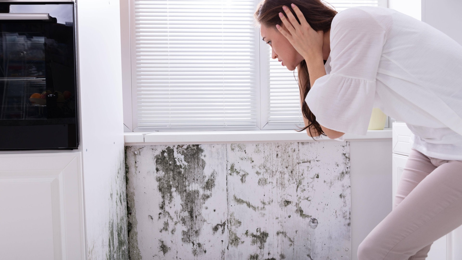 Foto: IMAGO, IMAGO / Panthermedia Frau erschrickt sich vor Schimmel an der Wand (Foto: IMAGO, IMAGO / Panthermedia)