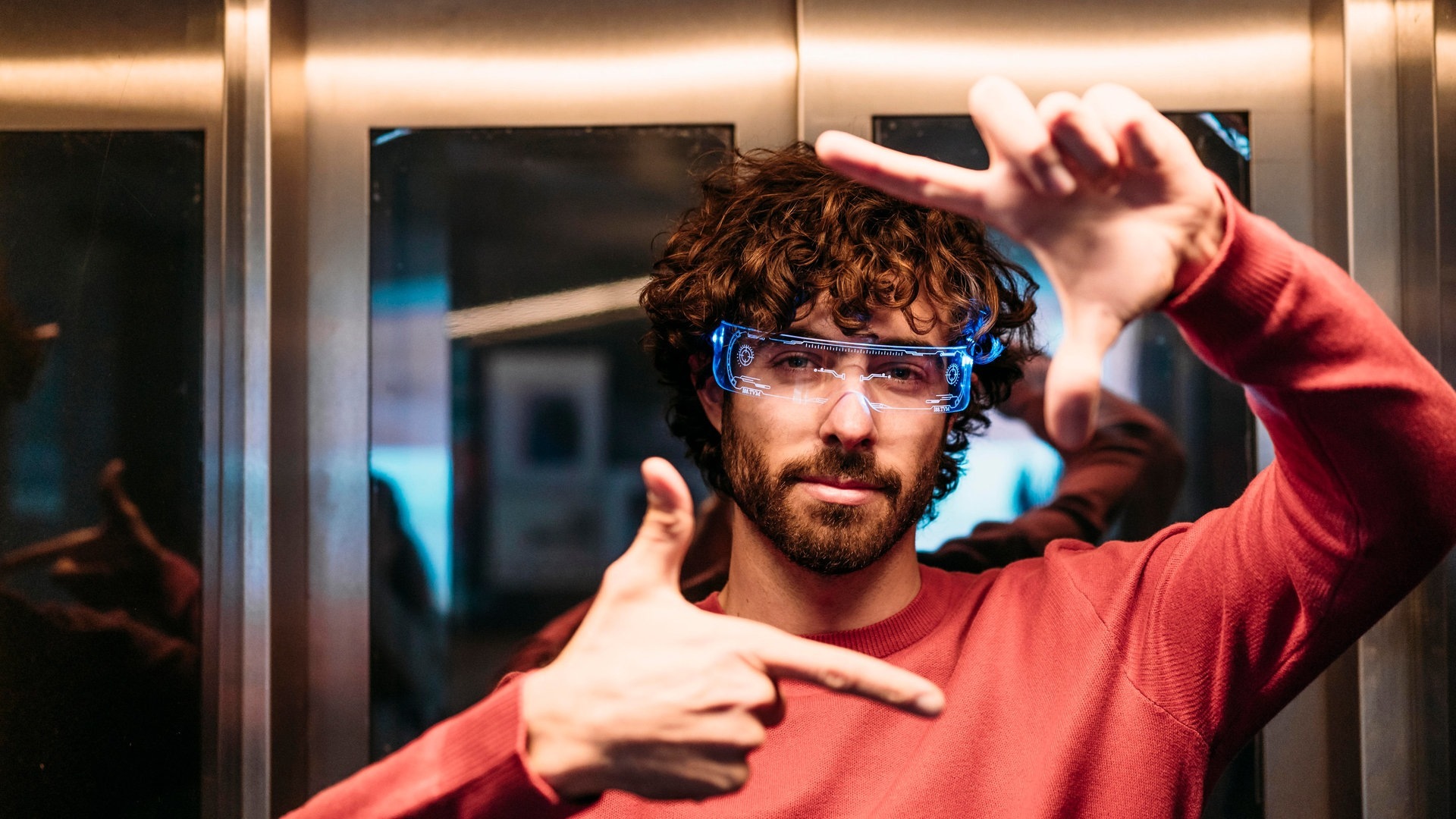 Ein Mann mit rotem Oberteil hat eine smarte Brille auf, die mit künstlicher Intelligenz funktioniert (Foto: picture-alliance / Reportdienste, picture alliance / Westend61 | Eva Blanco)