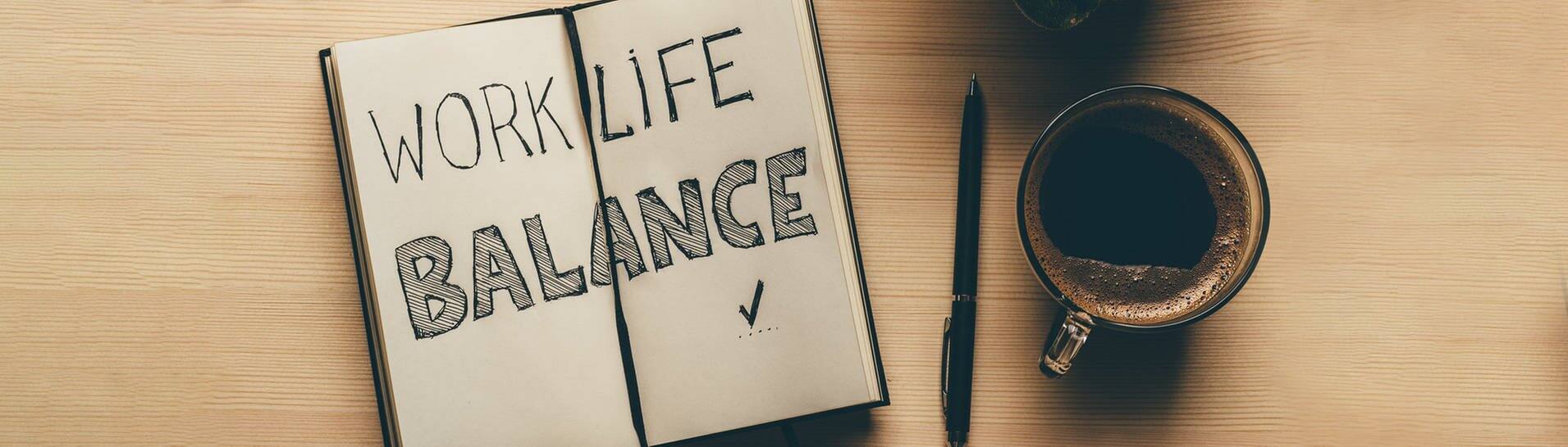 In einem Notiz-Buch steht das Wort Work-Life-Balance geschrieben. Das Buch liegt auf einem Schreibtisch mit Arbeitsutensilien. Wie wäre es mal mit Teilzeit-Arbeit? (Foto: Adobe Stock, DedMityay)