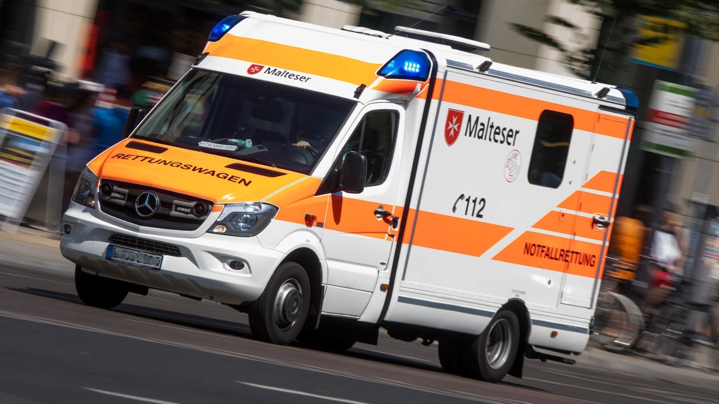 Rettungswagen fährt mit Blaulicht durch die Stadt