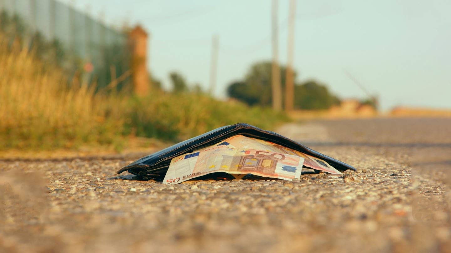 Verlorenes Portemonnaie mit Geld wartet auf einer Straße auf den Finder