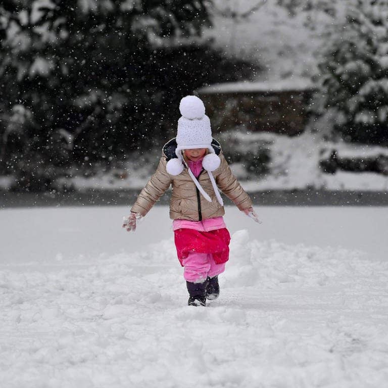 Ein Kind spielt im Schnee