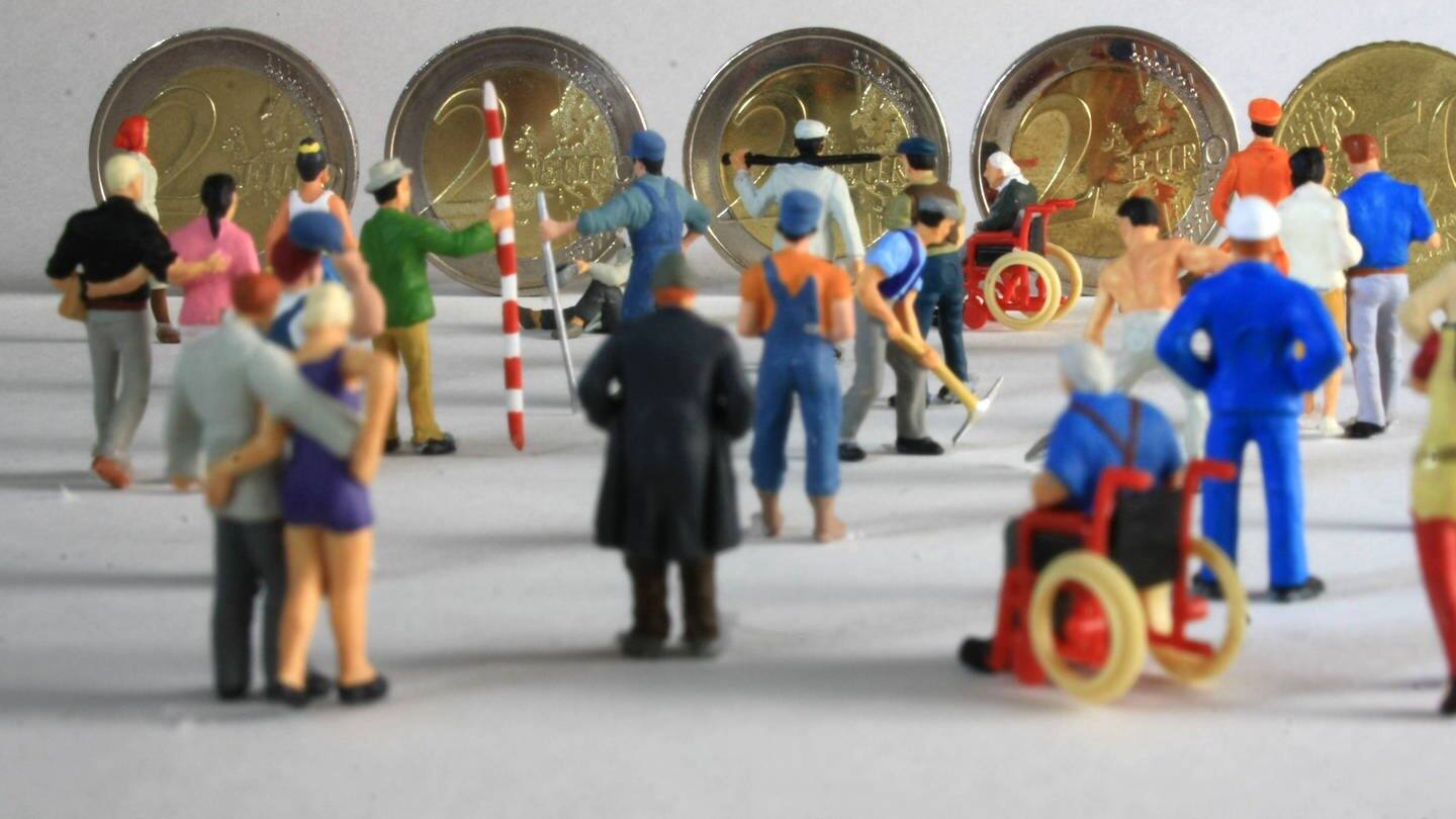 Symbolfoto Mindestlohn:Miniatur Figuren in Arbeitskleidung unterschiedlicher Branchen stehen vor Euro Geldmünzen im Wert von 8,50 (Foto: IMAGO, IMAGO / Ralph Peters)