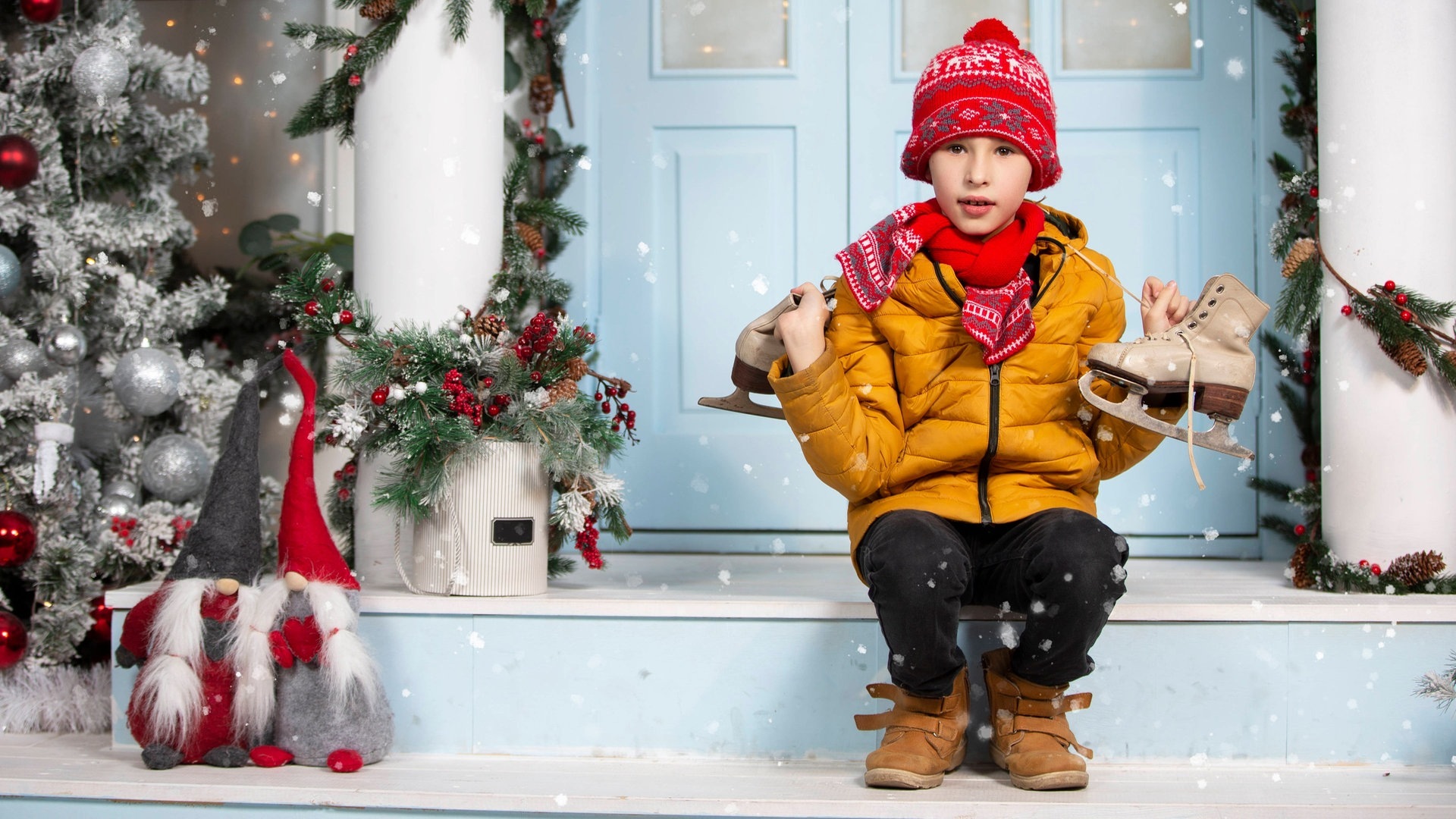 Weiße Weihnachten 2023? Junge sitzt mit Schlittschuhen auf der Treppe vor einer Haustür, Schnee fällt vom Himmel und es ist klassisch Winter. (Foto: IMAGO, IMAGO / Zoonar)