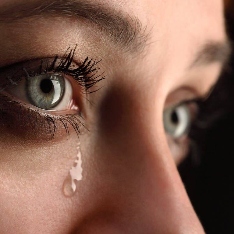 Frau mit grünen Augen weint dicke Tränen (Foto: Adobe Stock - Chepko Danil)