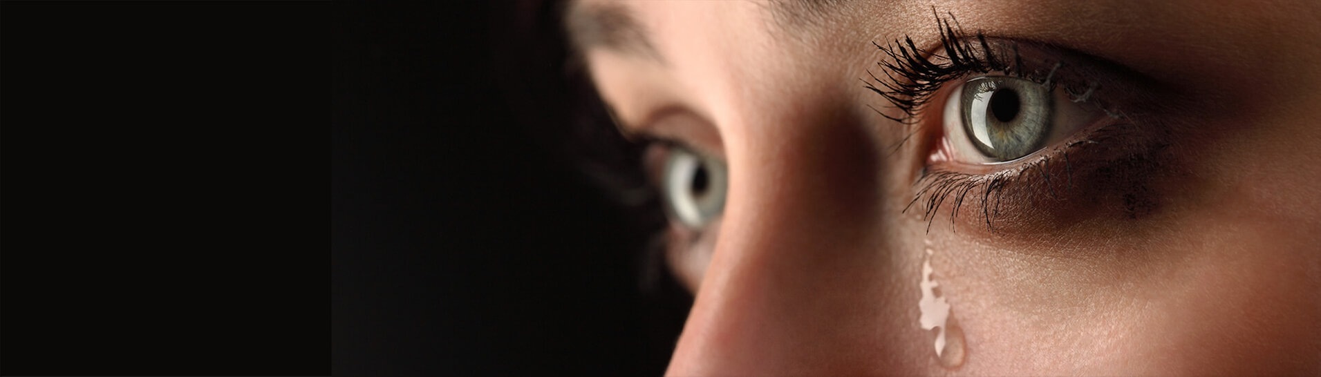 Frau mit grünen Augen weint dicke Tränen (Foto: Adobe Stock - Chepko Danil)
