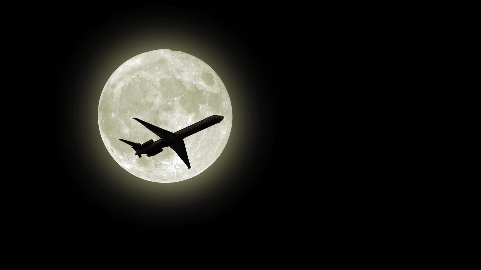 Flugzeug fliegt vor dem Mond (Foto: AdobeStock / photoncatcher36)