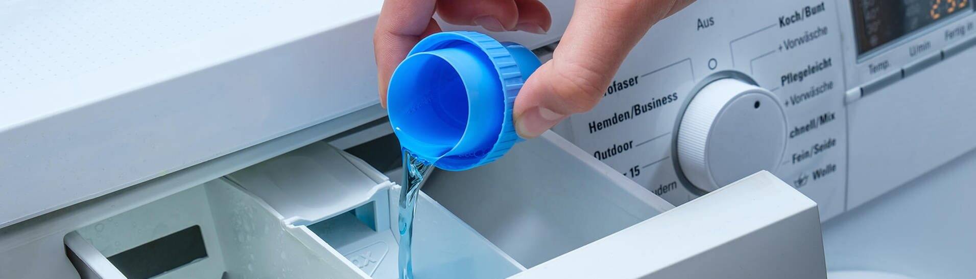 Hygienespüler in Waschmaschine füllen (Foto: AdobeStock / Guntar Feldmann)