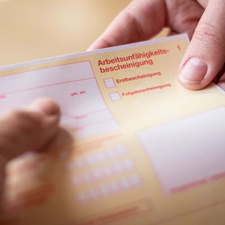 Krankenschein in der Hand (Foto: Adobe Stock / mpix)