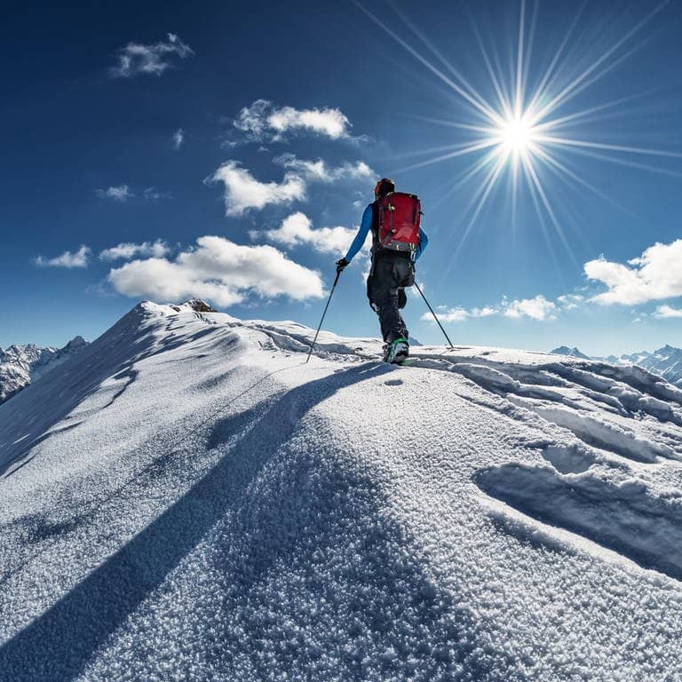Mit dem Snowboard auf den Gipfel (Foto: Adobe Stock / embredy)