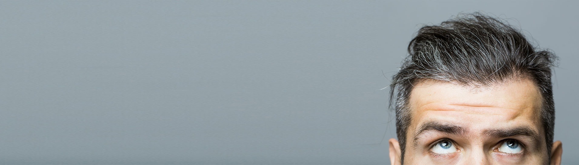 Mann schaut besorgt auf sein grau werdendes Haar  (Foto: Adobe Stock/Volodymyr)