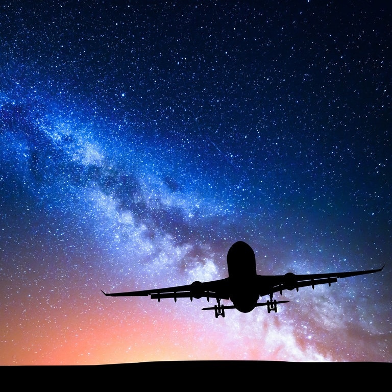 Flugzeug vor dem Sternenhimmel (Foto: Adobe Stock/den-belitsky)