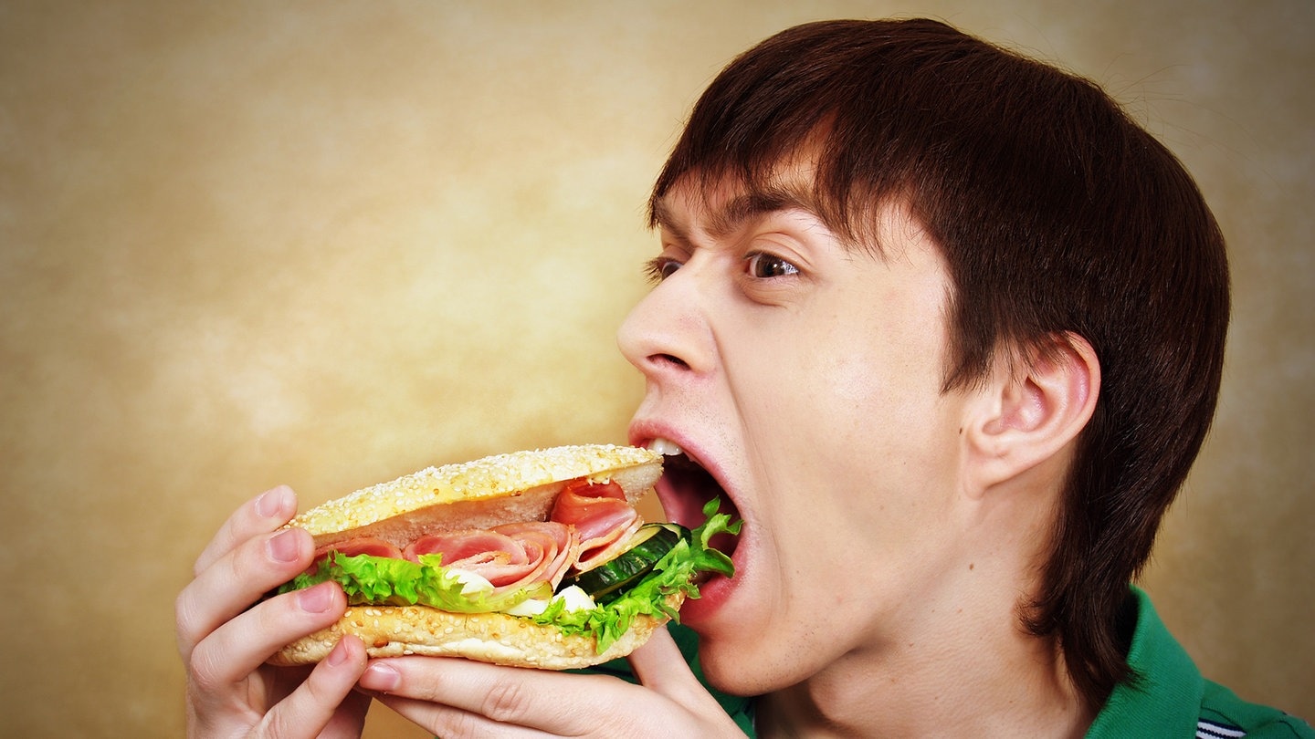 Mann der ein Sandwich isst (Foto: Adobe Stock / Natalia Uzkova)