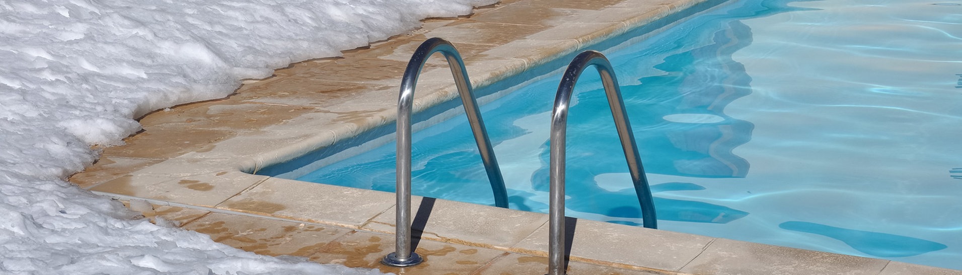 Bildausschnitt von Schwimmbecken, drumherum Schnee (Foto: Adobe Stock / coco)