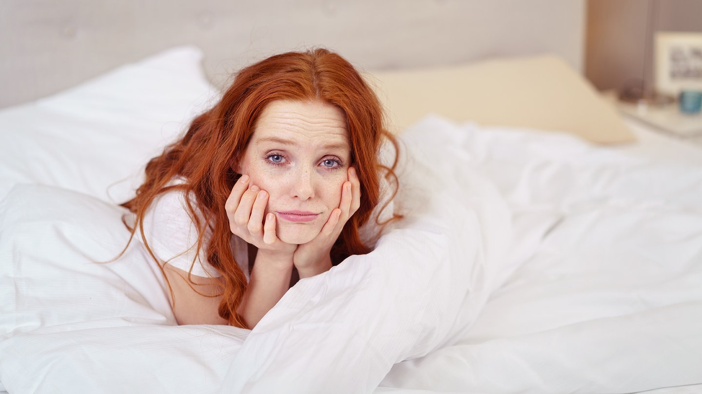 Frau sitzt noch müde im Bett (Foto: Adobe Stock/contrastwerkstatt)
