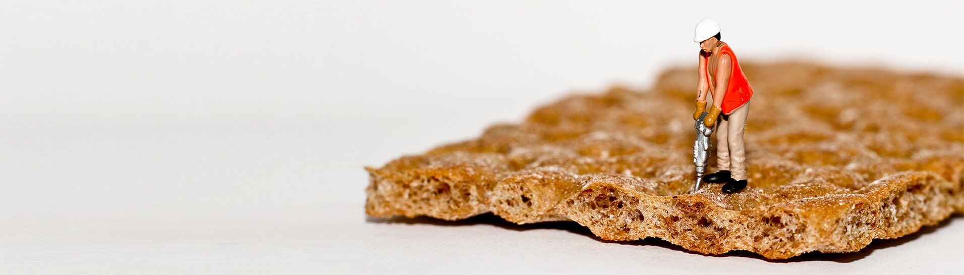 Miniatur-Figur mit Presslufthammer auf Knäckebrot (Foto: Adobe Stock / Phil Daub)